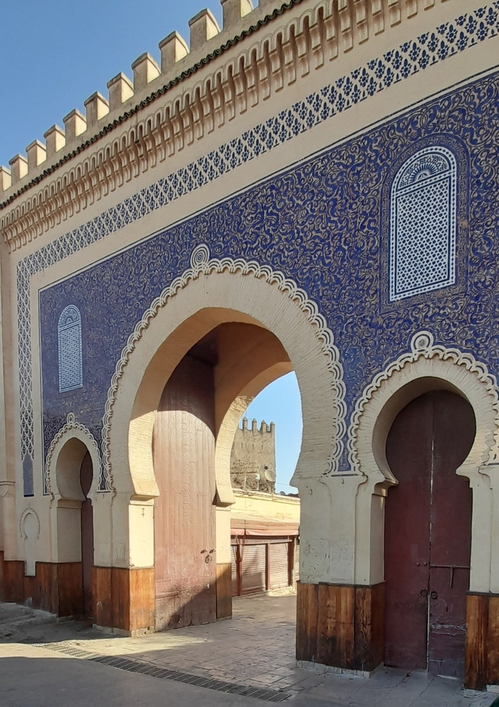 Portail orné avec des motifs complexes en carreaux bleus.