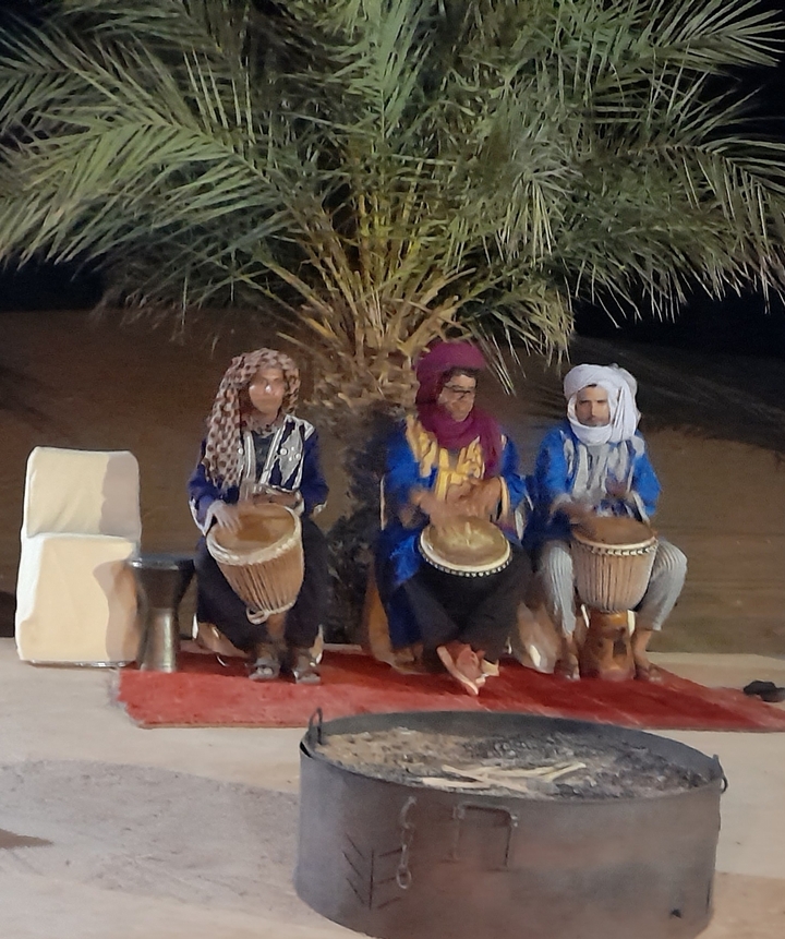 Image floue de trois personnes jouant de la batterie.