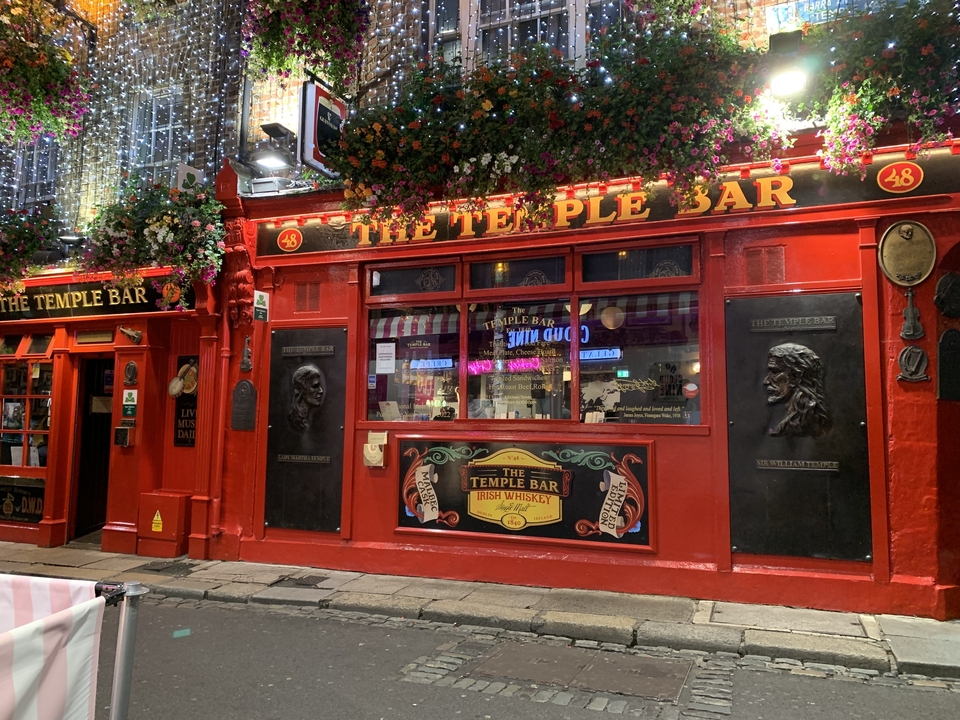 The Temple Bar, an iconic red pub front in Dublin with decorative elements.