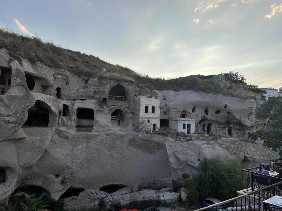 Cave dwellings carved into rock formations with visible openings.