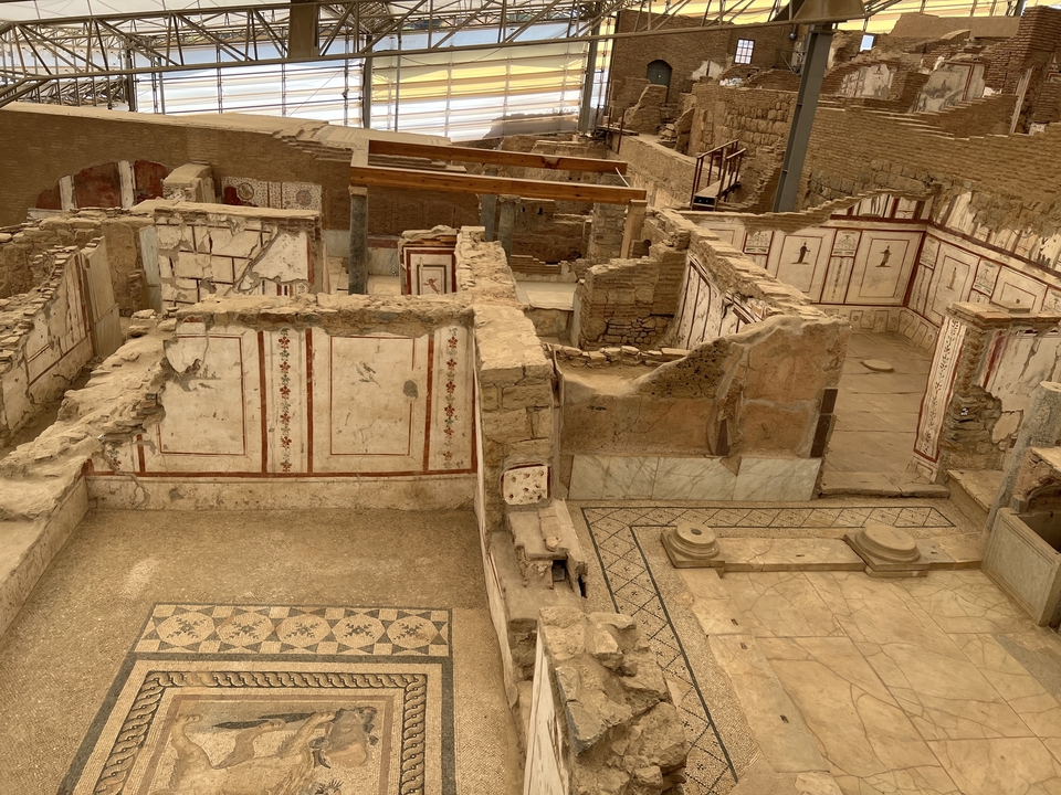 Ruins of ancient buildings with visible walls and mosaics.