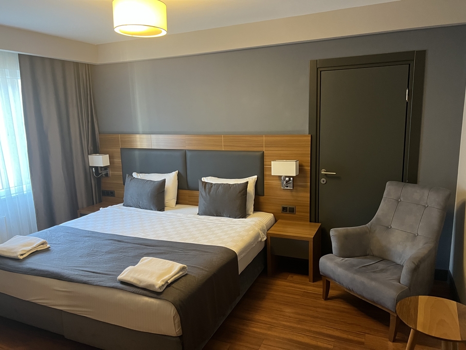 Hotel room with a bed, chair, and decor.