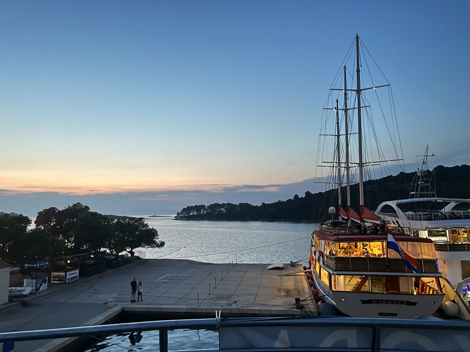 Petit yacht amarré à une jetée pendant le coucher du soleil.