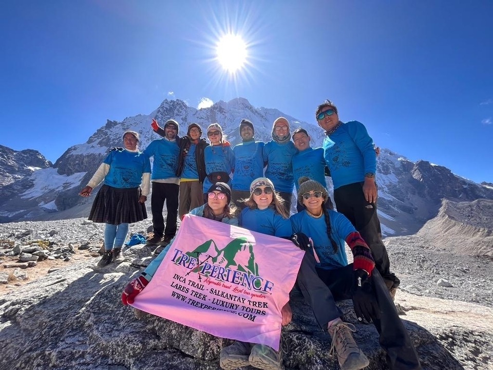 Group of hikers celebrating with a banner in the mountains.