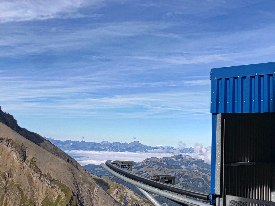 Blue metallic structure with mountainous landscape in the background.