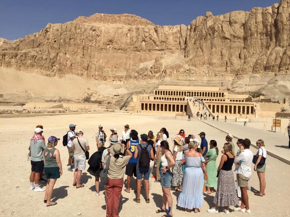 A large tour group visiting an ancient temple site.