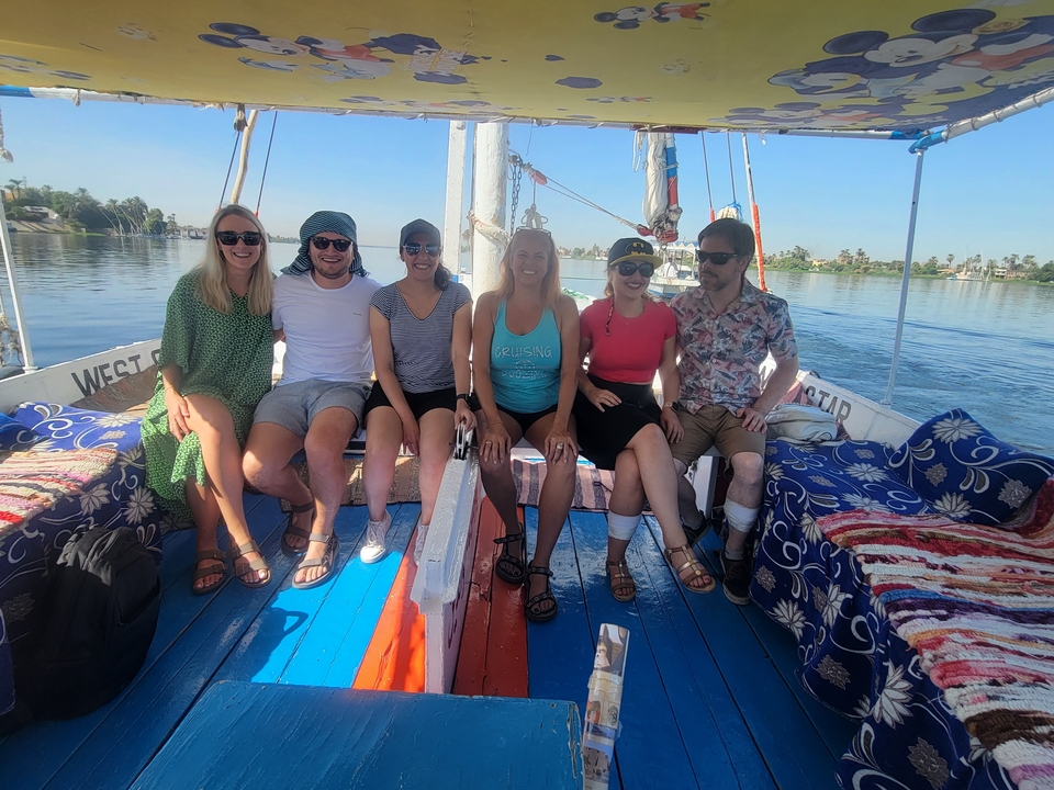A group of people sitting on a boat on a calm water body.