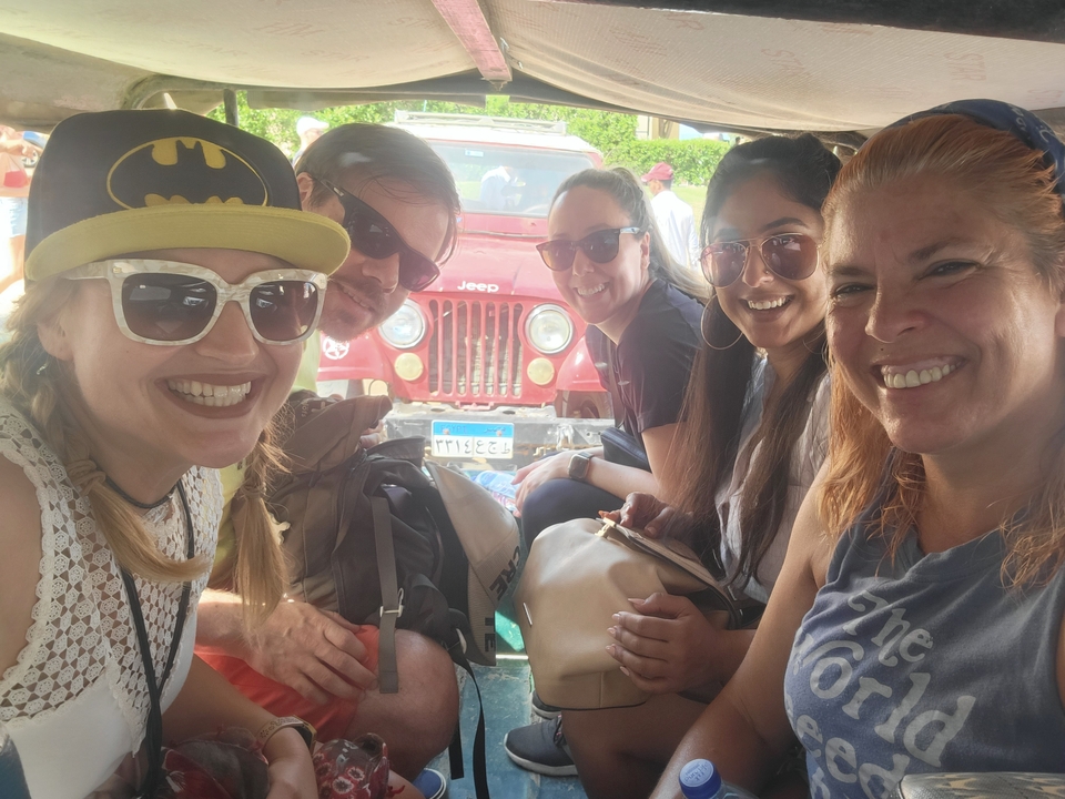 Smiling group of people inside a jeep, ready for adventure.