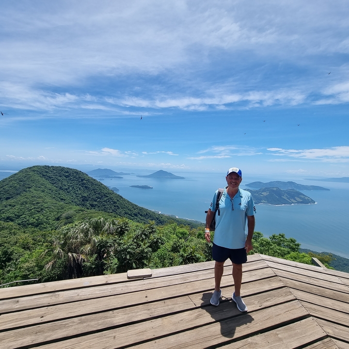 Person standing on a platform overlooking the ocean and islands.