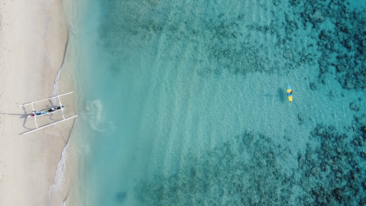 Aerial view of a beach with clear turquoise water.