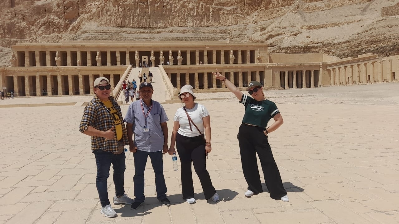Quatre personnes posent devant un temple antique.