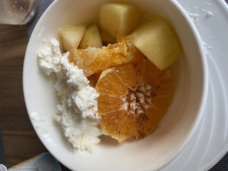 Fruit bowl with slices of orange and apple with cream.