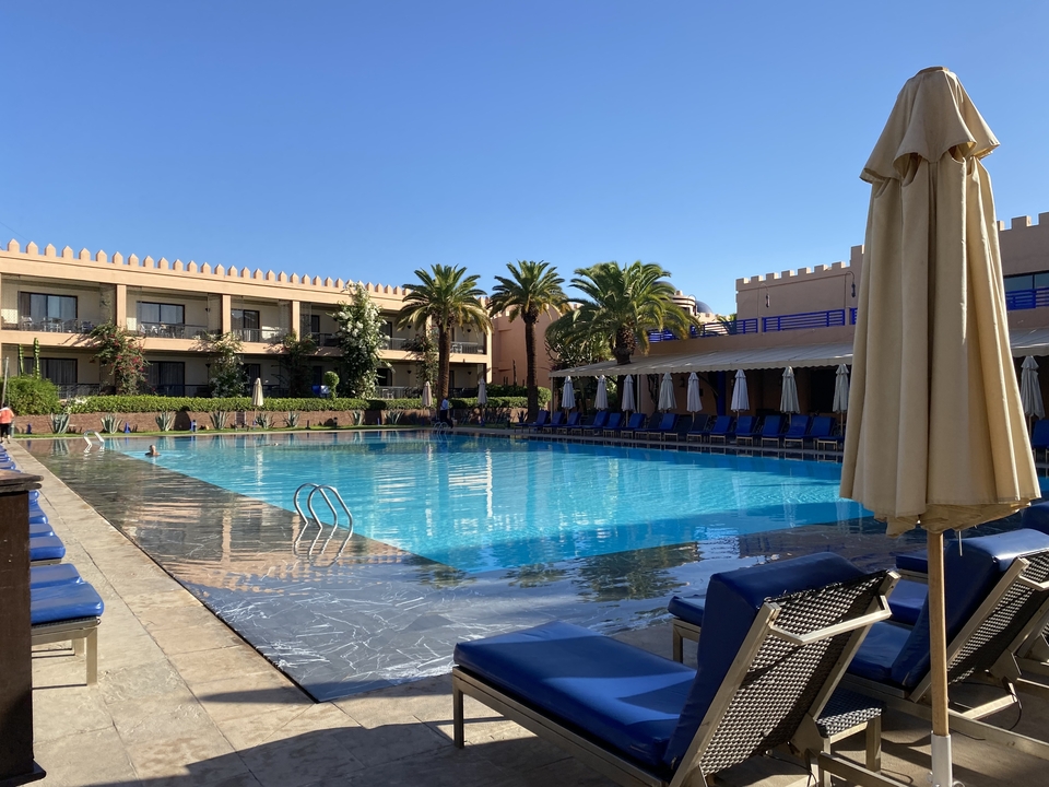 Luxurious poolside with lounge chairs and umbrellas.