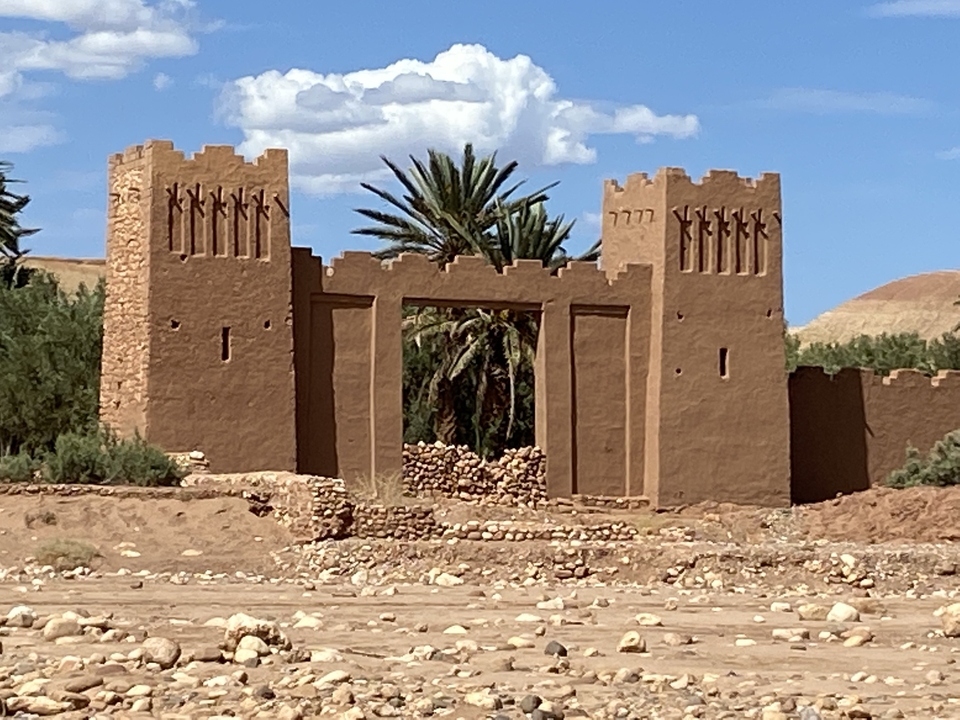 Ancient fortress entrance surrounded by palm trees.