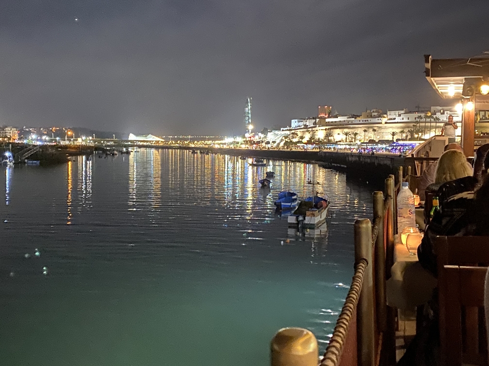 Night-time view of a lit waterfront with reflections.