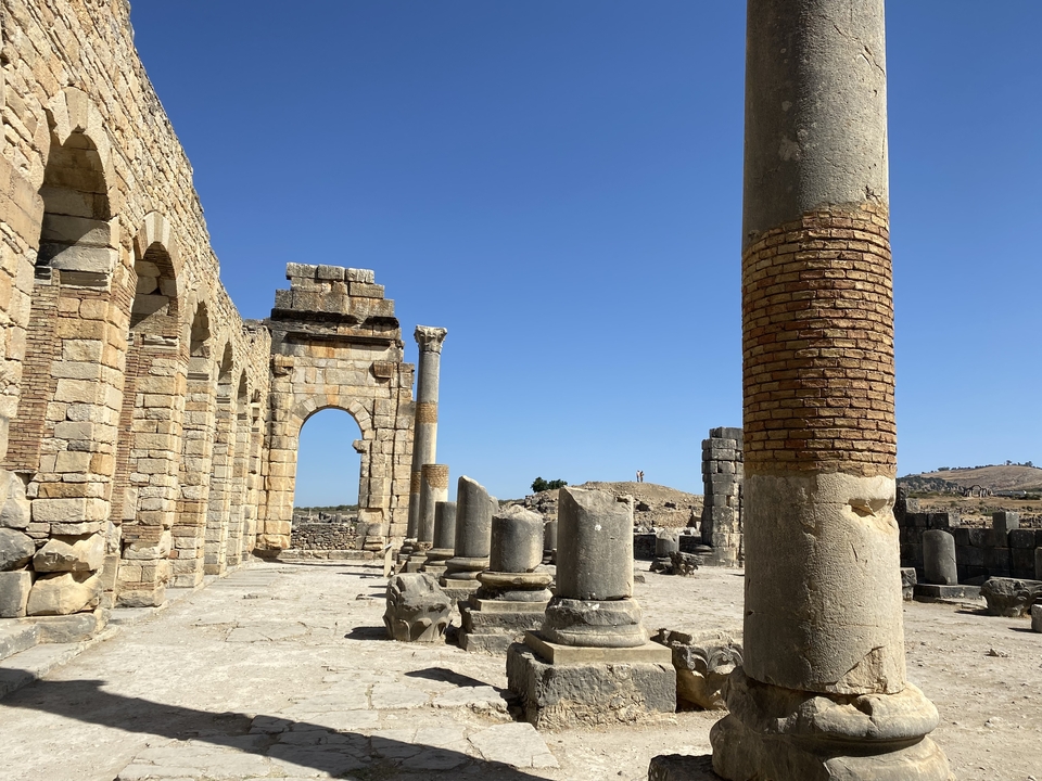 Ancient ruins with columns under a clear blue sky.
