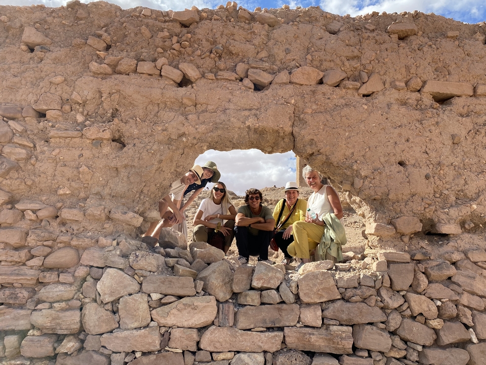 Group of friends posing through a rock window.
