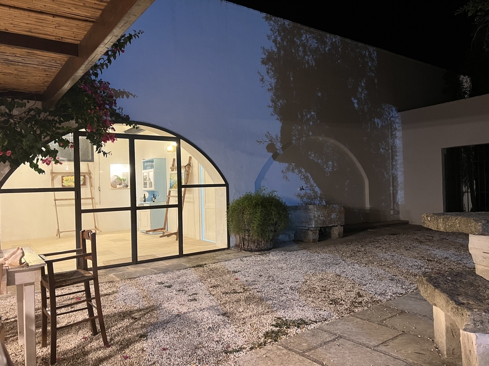 A building entrance at night with illuminated natural decor.