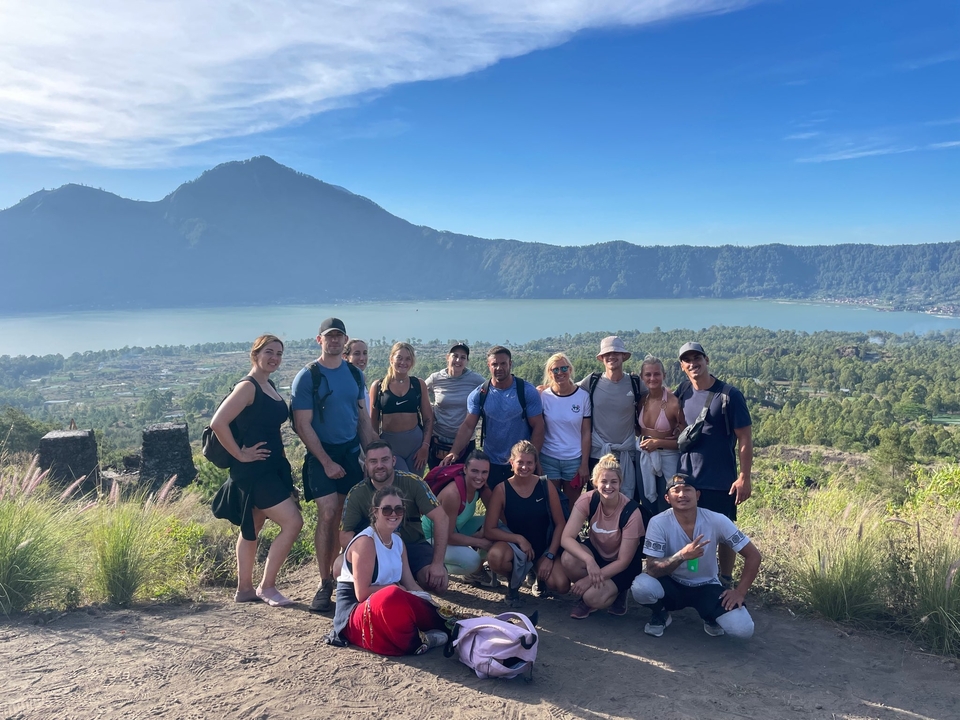 A group of people posing in front of a scenic mountain view.