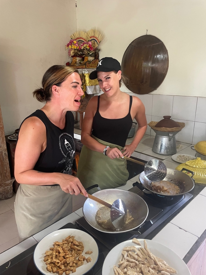 Two women cooking in a kitchen setting.