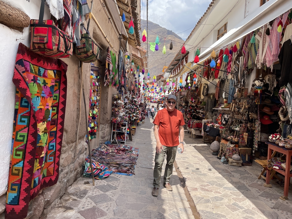 Homme marchant dans une rue de marché colorée et décorée.