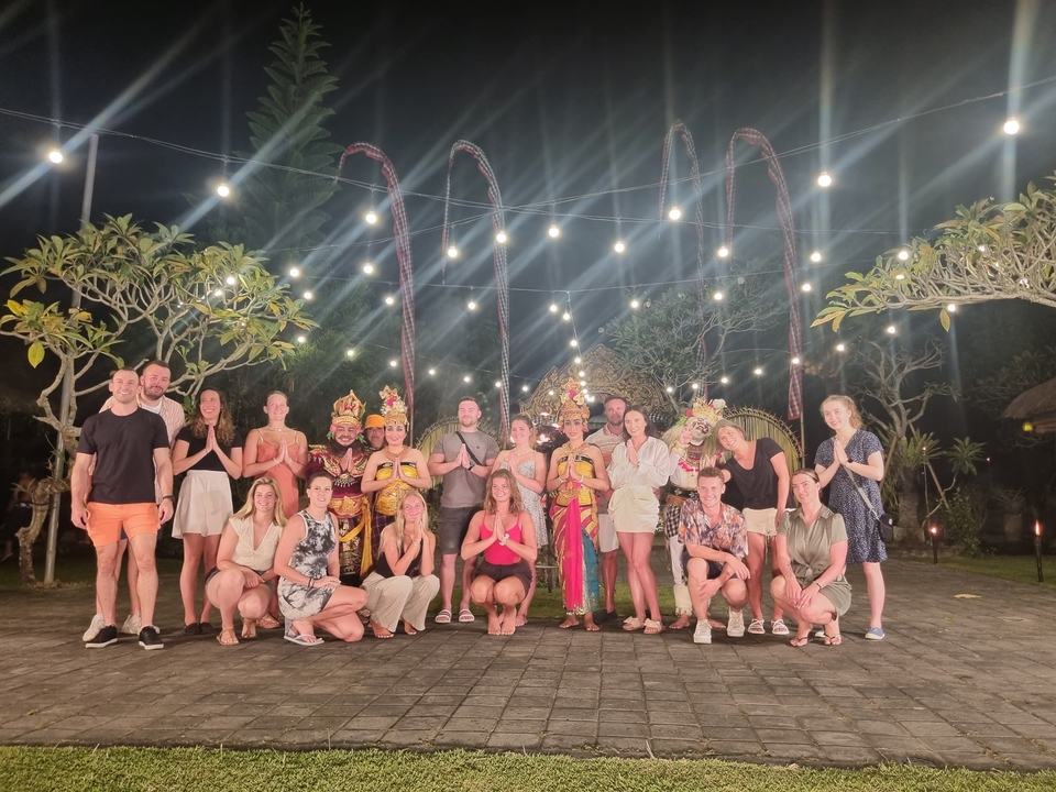 Group of people at night with local performers in costumes.