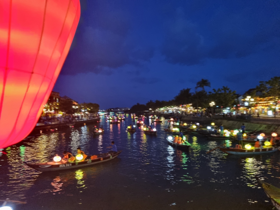 Boats with lanterns on a river at night.