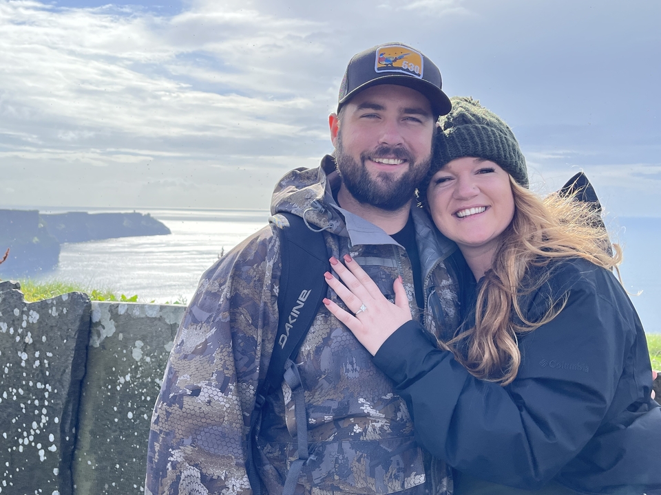 Couple smiling with the ocean in the background.
