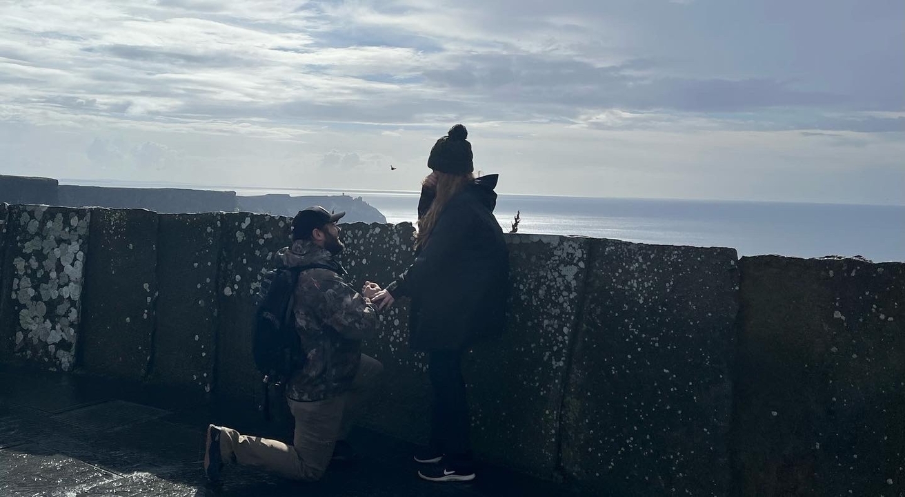 Scène de demande en mariage à un point de vue panoramique sur l'océan.