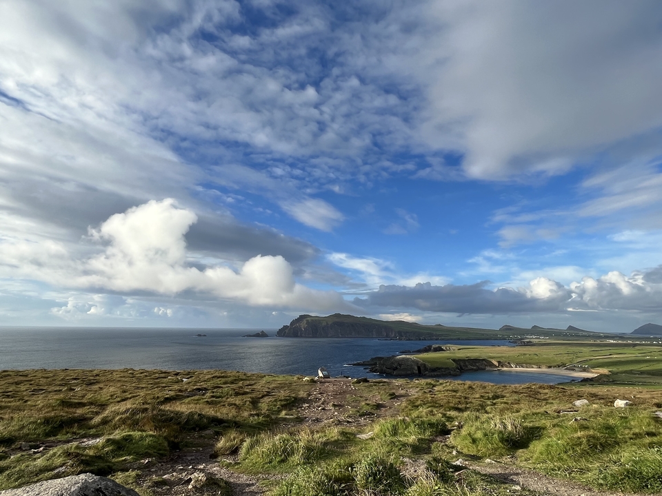 Scenic coastal view with sea and cliffs under a blue sky.