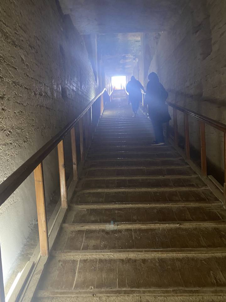Indoor stairway with people walking down.