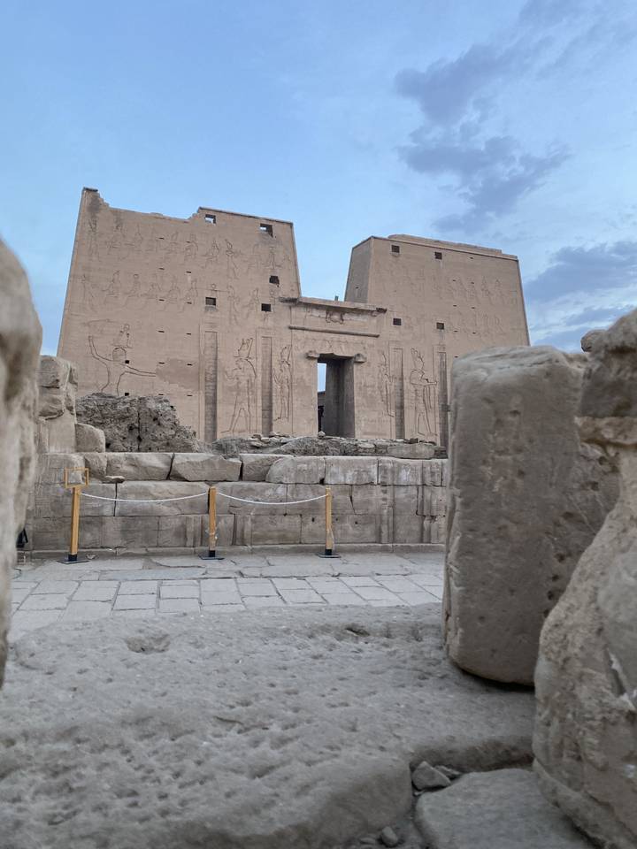 Ruins with carved figures on stone walls.