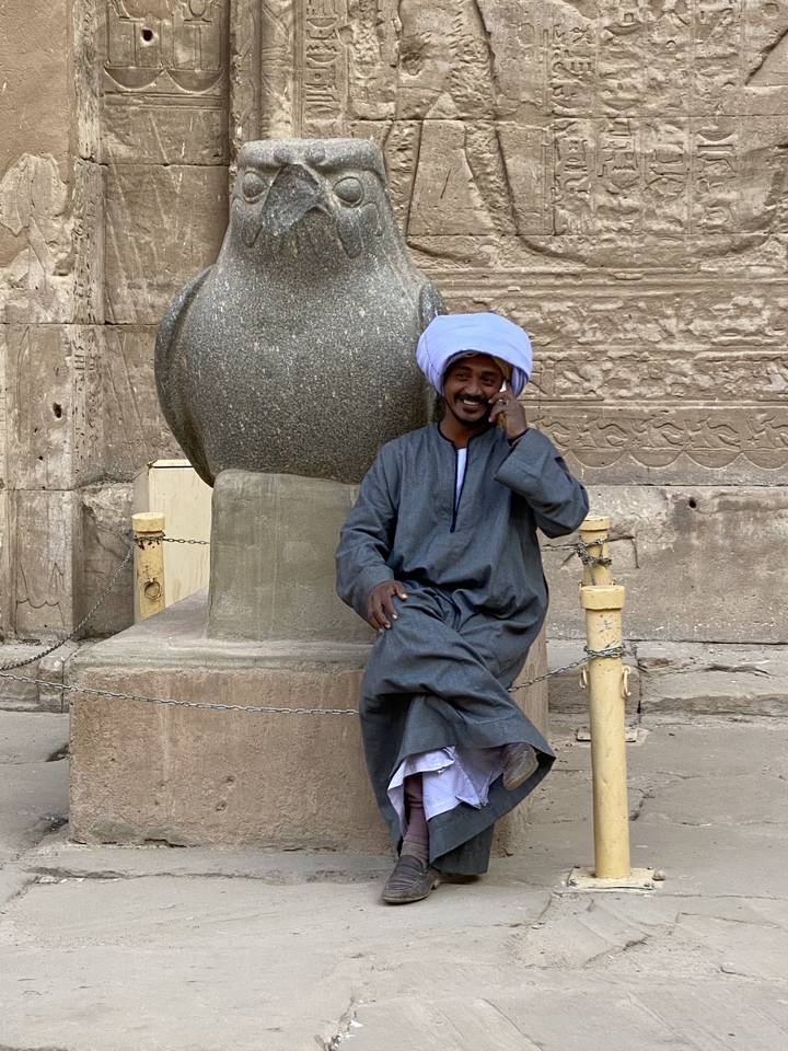 Person sitting against an ancient statue.