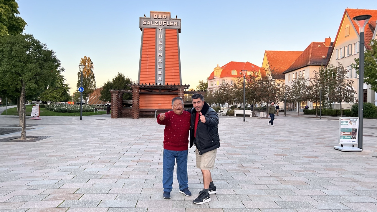 Deux hommes posant devant un bâtiment de bains thermaux.