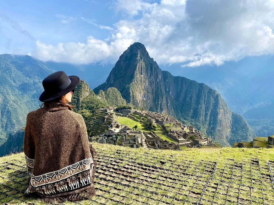 Personne contemplant le Machu Picchu avec des montagnes en arrière-plan.