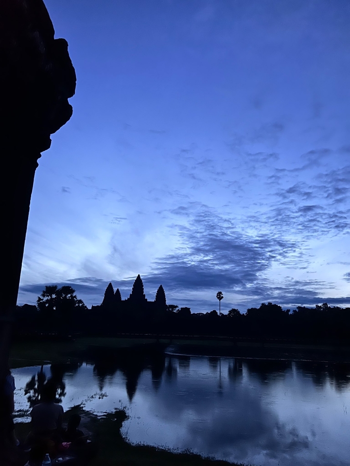 Silhouette of a temple against a blue twilight sky.