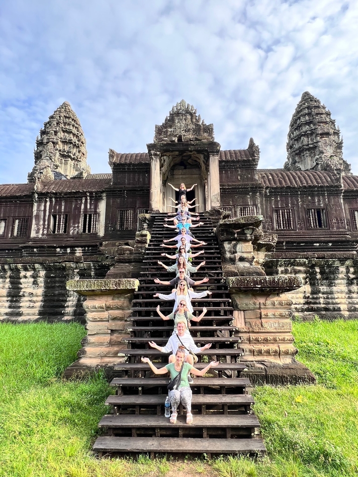 People posing on ancient temple steps.
