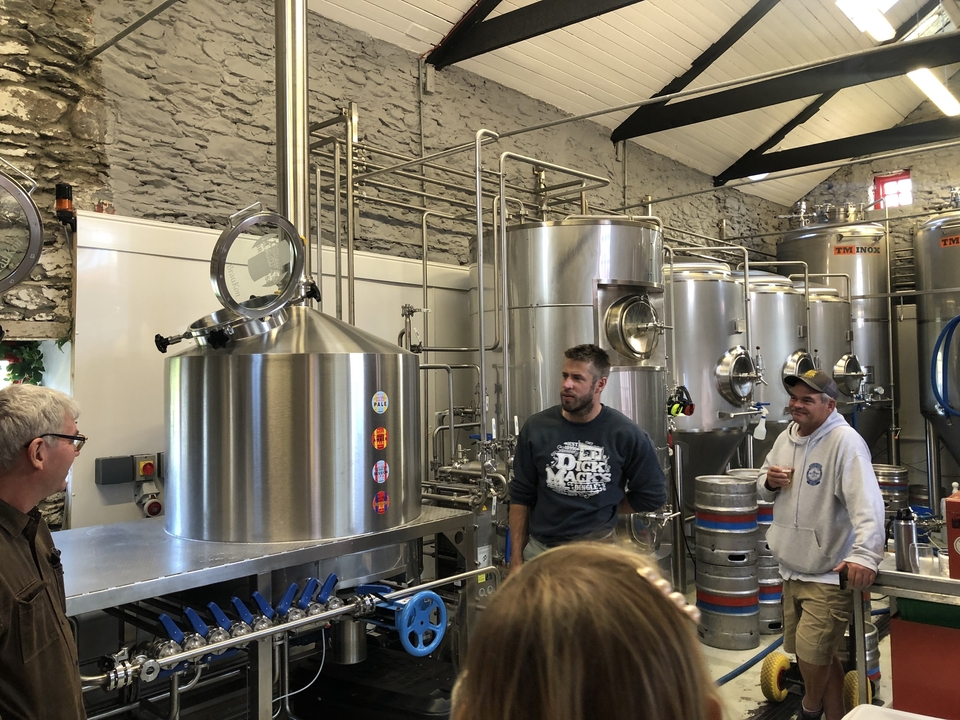 People in a brewery setting.

Translation: Des gens dans un environnement de brasserie.