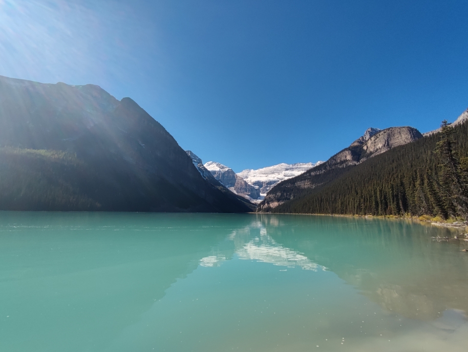 Aquamarine lake surrounded by mountains and forests.