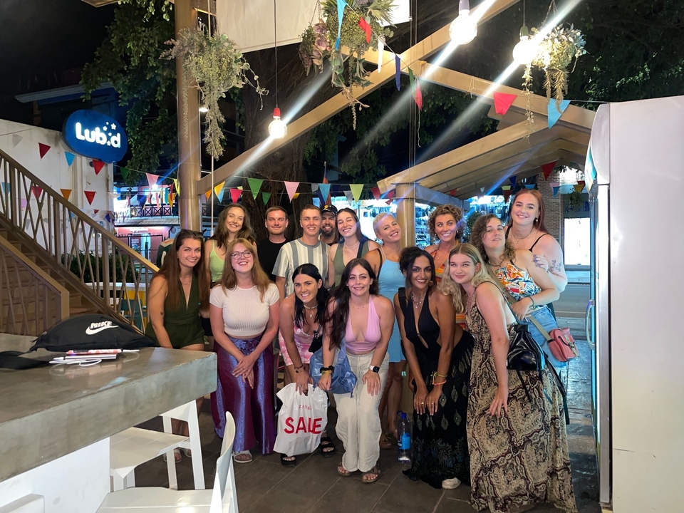 Group of people posing in a lively outdoor setting.