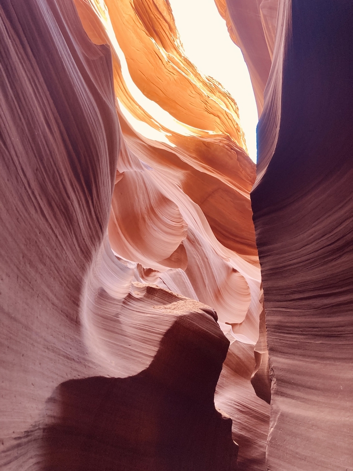 Curved sandstone formations viewed from within a narrow canyon.
