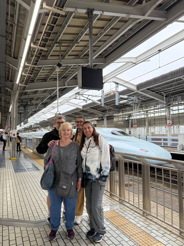Group at a train station, possibly waiting for a bullet train.