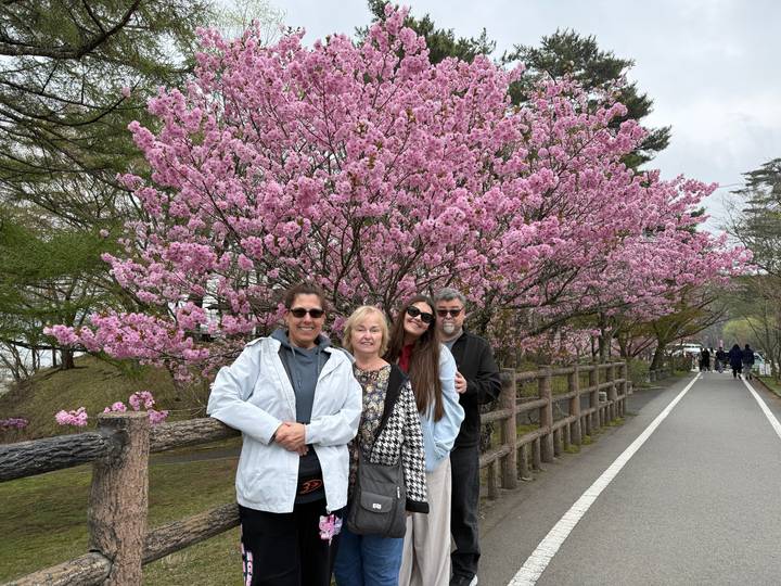 Group posing under cherry blossoms.