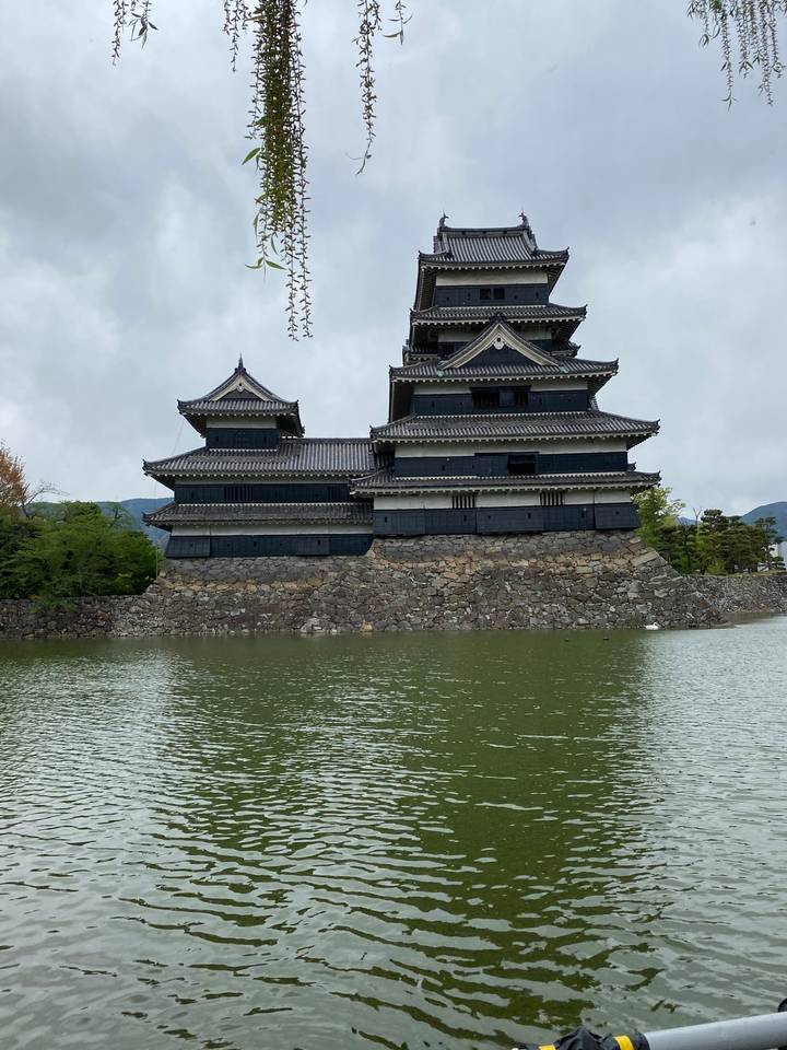 Castle structure with traditional roofing, surrounded by water.