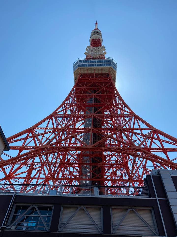 Red steel tower structure against a blue sky.