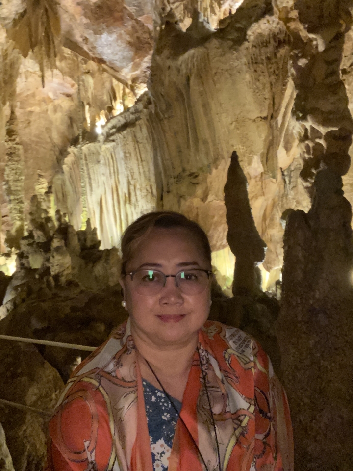 Femme dans une grotte avec des stalactites.