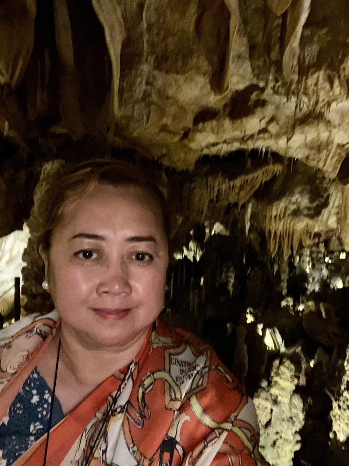 Femme dans un décor de grotte avec des stalactites en arrière-plan.