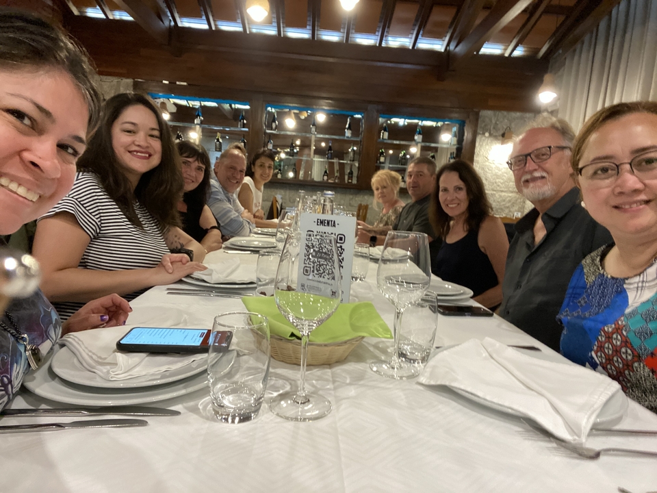 Group of people dining indoors at a long table.