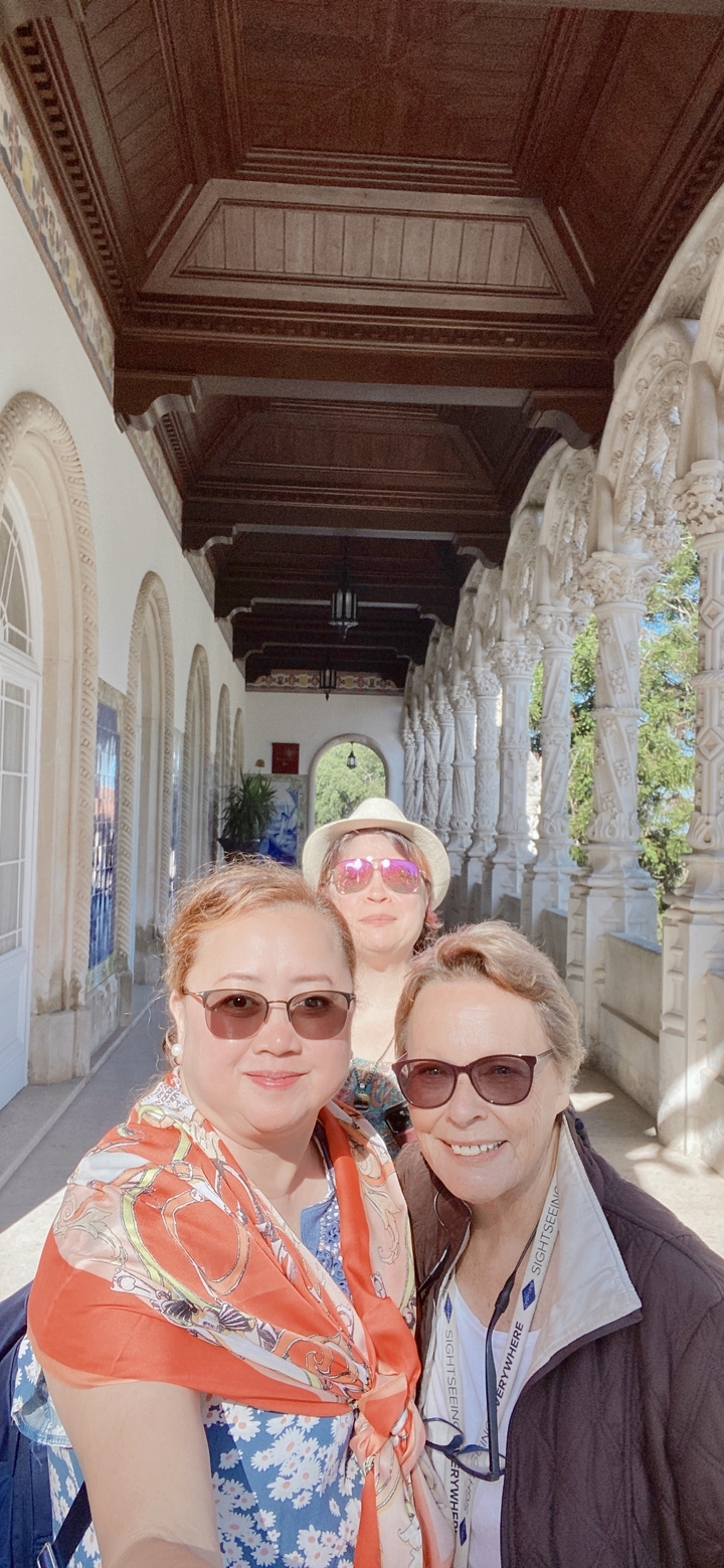 Three women taking a selfie in a decorated corridor.