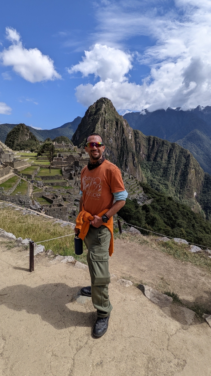 Personne posant au Machu Picchu avec les ruines en arrière-plan.
